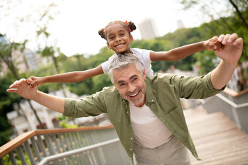 Beaming beautiful daughter feeling happy with daddy