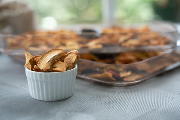 Dried apple slices in a handmade bowl and fresh apples