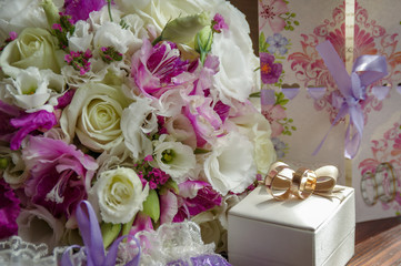 Wedding bouquet with wedding rings. Gold wedding rings lie near the bouquet for the bride. Wedding accessories