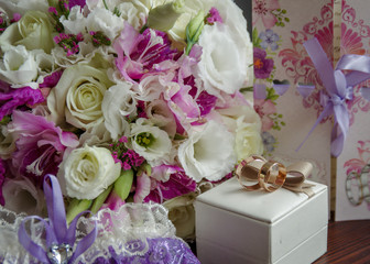 Horizontal shot of wedding rings with a bouquet of the bride. The concept of a wedding day