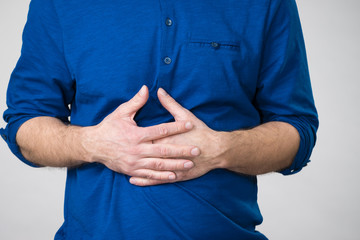 Man having crossed fingers on his stomach
