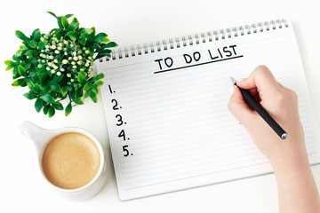 Female hand writes To Do List in notebook, planning concept