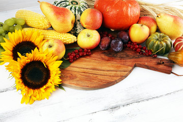 Autumn nature concept. Fall fruit and vegetables on wood. Thanksgiving dinner and sunflower