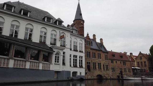 Bruges, Belgium - May 2019: View of the water channel in the city center. Boat trip along the water canals of the city.