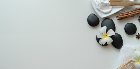 Top view of black stones and accessories for massages on white background