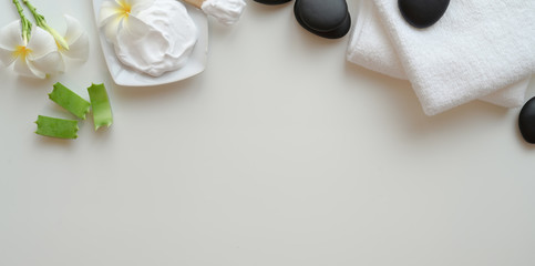 Top view of black stones and towels for massages on white background