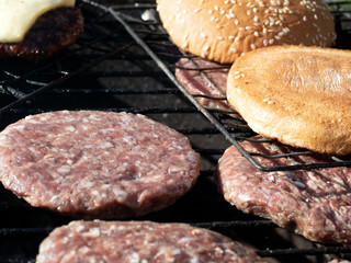 On the grill, home-made meat with cheese and a burger bun