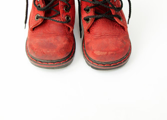 Old red baby boots on white background