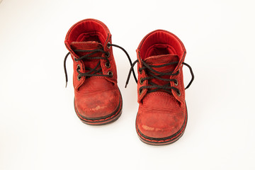 old red baby shoes on white background. close up