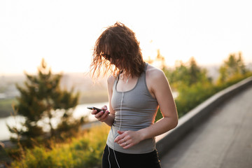 woman in sunglasses with headphones in the park