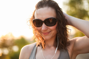 woman in sunglasses with headphones in the park