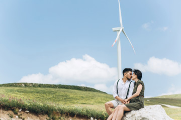 A young couple sit together and kiss. Intimate relationships and love.