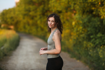 caucasian woman in sports in park at sunset,