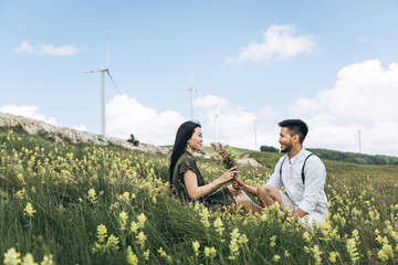 A guy gives his girlfriend meadow flowers. Romance and love.