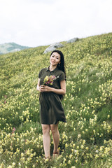 Beautiful girl with a bouquet of wildflowers in her hands.