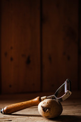 POTATOES WITH CUTTER ON WOODEN TABLE. RUSTIC FOOD PHOTOGRAPHY