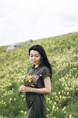 Beautiful girl with a bouquet of wildflowers in her hands.