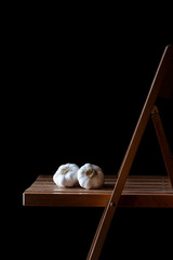 WHITE GARLIC ON WOODEN CHAIR AND DARK BACKGROUND. RUSTIC FOOD PHOTOGRAPHY