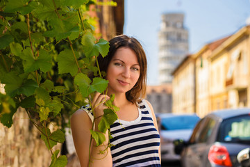 Outdoor photo of beautiful woman, posing on Pisa street, near the famous falling tower.