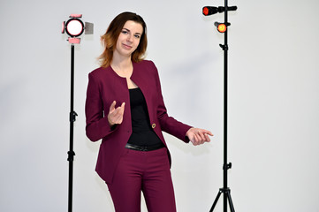 Portrait of a pretty young brown-haired business woman on a white background in a dark business...