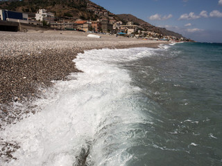 Beautiful clear water of Mediterranean sea, Pebble coast of Sicily, summer holiday. Selective focus.