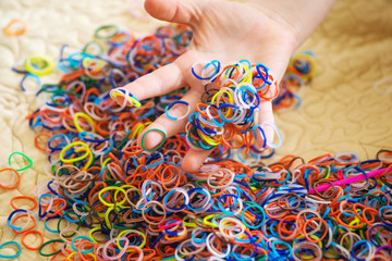Holding a pile of colorful rubber bands in hand.