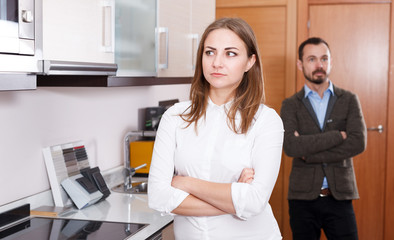 Upset girl with husband in kitchen furniture salon