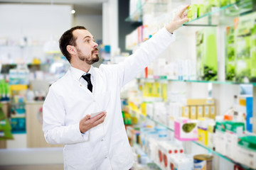 Male pharmacist searching for reliable drug