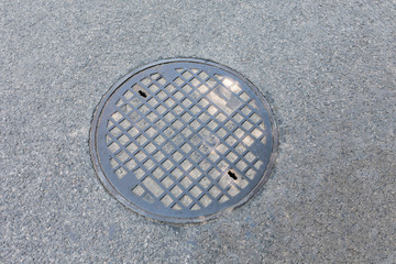 Sewer manhole, manhole in the asphalt street.