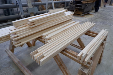 Parts of wooden windows from glued beams from pine with chopped mortise and tenon joints after profiling operation.