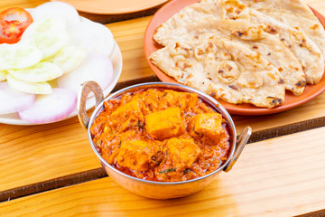 Indian Delicious Spicy Vegetarian Cuisine Paneer Toofani Also Know as Paneer Tufani, Toofani Paneer Masala or Dhaba Style Paneer Masala Served with Tandoori Roti on Wooden Yellow Background