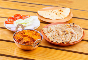 Indian Delicious Spicy Vegetarian Cuisine Paneer Toofani Also Know as Paneer Tufani, Toofani Paneer Masala or Dhaba Style Paneer Masala Served with Tandoori Roti on Wooden Yellow Background