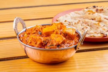 Indian Delicious Spicy Vegetarian Cuisine Paneer Toofani Also Know as Paneer Tufani, Toofani Paneer Masala or Dhaba Style Paneer Masala Served with Tandoori Roti on Wooden Yellow Background