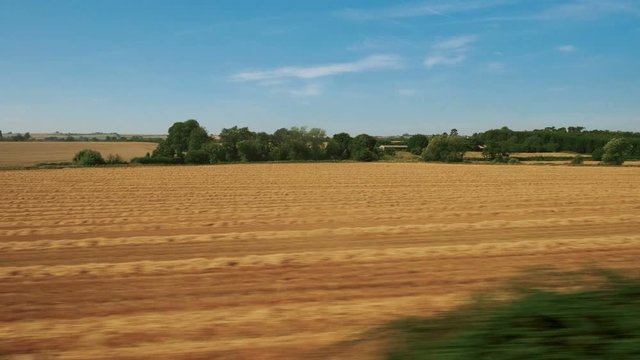 Passenger view of amazing croplands and rolling hills in the Cotswolds in England, UK, an Area of Outstanding Natural Beauty with 787 square miles, the second largest protected landscape in England