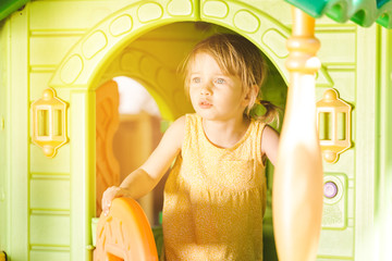Little girl being absorbed playing in a hut