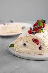 Meringue roll cake with cream and raspberries. Roulade, summer dessert, closeup.