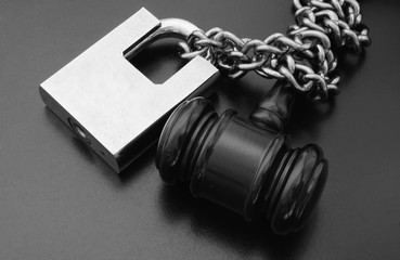 Wooden gavel locked with padlock and chain 