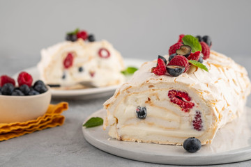 Meringue roll cake with cream and raspberries. Roulade, summer dessert, closeup.