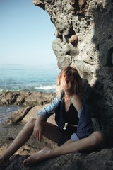 Attractive young model posing on rock 