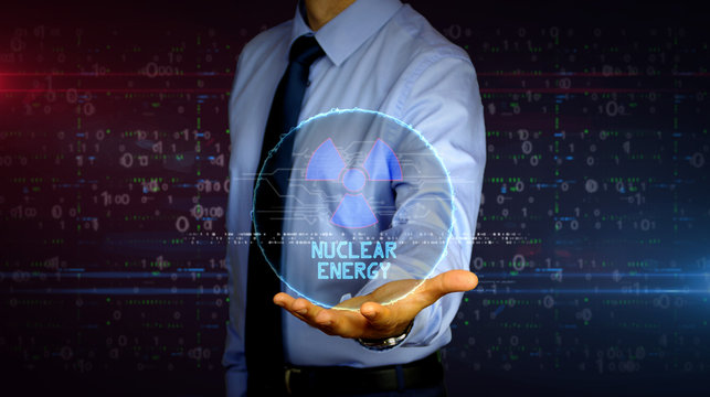 Businessman with nuclear energy symbol hologram