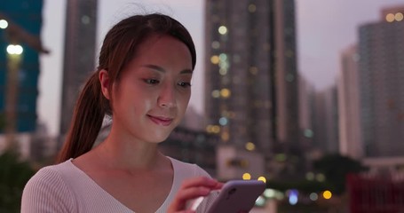 Woman use of mobile phone in city at night