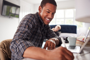 Two Male College Students In Shared House Bedroom Studying Together