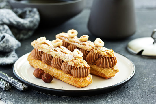 Homemade eclair with chocolate and nuts. Pastry.
