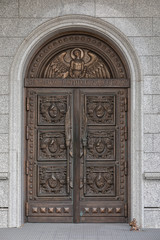 Arched wooden door of church with wood-carving