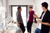 Group Of Male College Students Eating Breakfast And Hanging Out In Shared House Kitchen Together