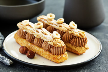 Homemade eclair with chocolate and nuts. Pastry.