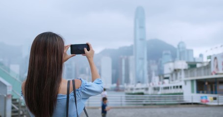 Woman tourist take photo on cellphone in Hong Kong