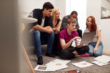 Group Of College Students In Lounge Of Shared House Studying Together