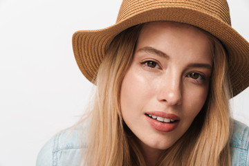 Serious amazing young pretty woman wearing hat posing isolated over white wall background.