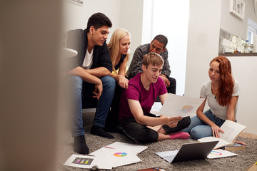 Group Of College Students In Lounge Of Shared House Studying Together